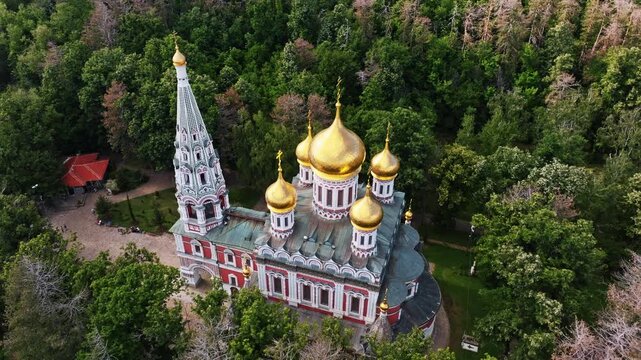 Shipka Memorial Church Orthodox Monastery golden domes aerial drone view lush green forest Balkan mountains architecture religious landmark travel Bulgaria