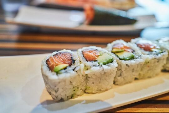 Close-up of salmon and avocado maki pieces on a plate