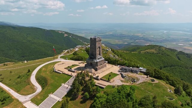 Shipka Pass Freedom Monument aerial drone view stone tower Balkan mountains peak summer sunny day historical landmark travel Bulgaria national flag
