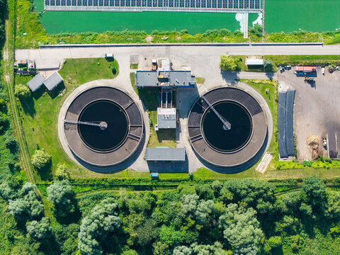 Aerial view of the Sloka wastewater treatment plant in Jurmala, featuring circular sedimentation tanks and a floating solar power plant on the adjacent pond, Jurmala, Latvia.