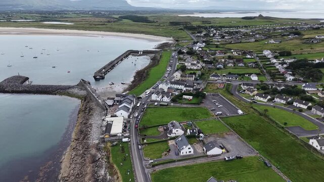 Aerial top view of picturesque Irish village in the northwest of Ireland, Mullaghmore, County Sligo. Drone footage showcasing a beautiful harbour full of boats, yachts, ships moored along the