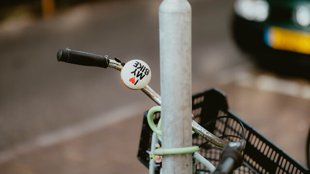 Close up of bike handlebar with sticker on city street
