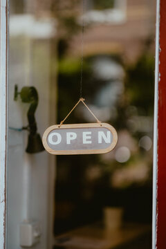Open sign hanging on door inviting customers inside