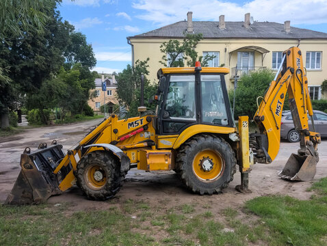 Grodno, Republic of Belarus. - August 06, 2026: The MST backhoe loader is a multi-functional wheeled machine that combines the functions of a front-end loader and a backhoe excavator.