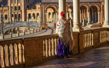 the beautiful girl in the square wraps herself in her splendid Andalusian shawl © corradobarattaphotos