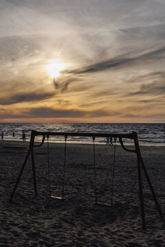 Swings on sandy beach with sea view during sunset in Majori in Jurmala, Latvia