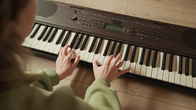 Close view of person playing vintage electronic keyboard with both hands pressing keys, forming chords and moving through accompaniment in warm indoor light with subtle motion blur and focused
