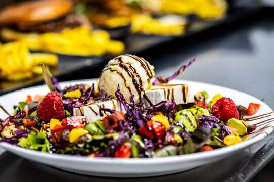 Gourmet salad featuring goat cheese, mushroom ice cream, berries, and balsamic glaze