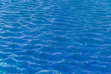 Fototapeta premium Rippling azure waters reflecting sunlight on a tranquil summer afternoon by the beach