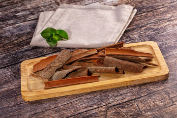 Cinnamon sticks on wooden tray with mint leaves and linen napkin © Andrei Starostin