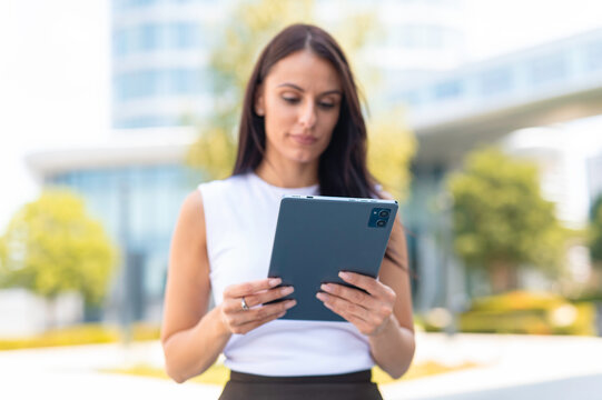 Businesswoman using digital tablet outdoors in city