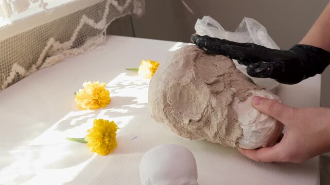 Handmade papermache calavera skull in DIY finish shot with yellow flowers for Day of the Dead decor