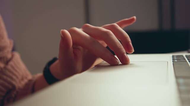 Close-up of right hand hovering above laptop keyboard, fingertips curved and slightly lowered, showing poised typing or light tapping motion with subtle finger movement in warm indoor workspace