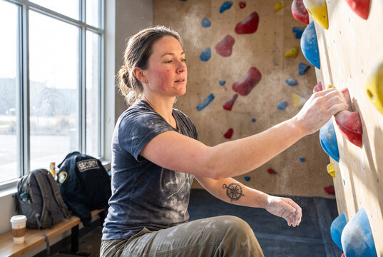 Bouldering Athlete Training on an Indoor Wall in a Sunlit Climbing Gym