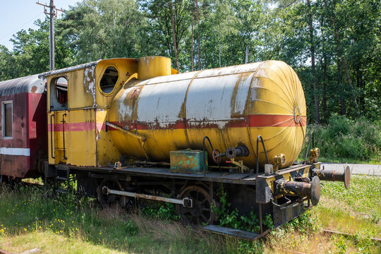 Rusty Yellow Train Tanker Railcar Abandoned Vintage Carriage on Overgrown Railway Track