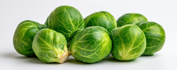 Obraz premium Fresh green Brussels sprout vegetable close up with natural texture and vibrant color on white background, healthy food concept