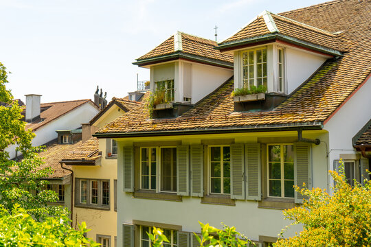 European Houses with Tiled Roofs, Dormer Windows and Lush Green. Old city architecture. Cityscape in Zurich Switzerland