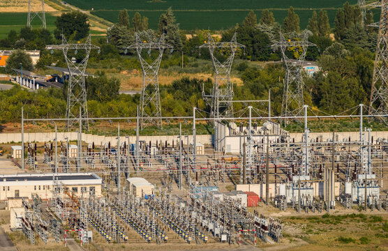 Aerial view of a high voltage electrical substation with transformers, switchgear and transmission towers distributing power in Saulce-sur-Rhone, Auvergne-Rhone-Alpes, France.