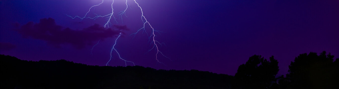 &Eacute;clairs ramifi&eacute;s illuminant un ciel d&rsquo;orage violet au-dessus d&rsquo;un paysage nocturne