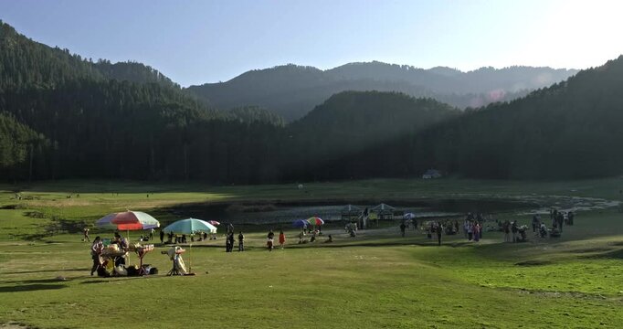 Scenic Full View of Khajjiar Lake at Golden Hour with Green Meadow and Cedar Pine Forests in Chamba Himachal Pradesh India