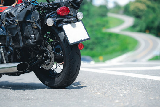 Motorcycle with saddlebags parked on winding road, showcasing adventure and freedom