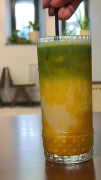 matcha drink Fresh mango smoothie in glass with mint garnish, tropical fruit shake on wooden background, healthy yellow mango lassi for summer wellness