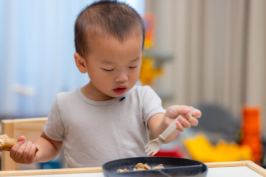 Little boy holding fork eating