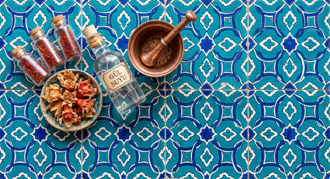 Overhead flat lay of Turkish saffron and pomegranate apothecary items on Iznik tile