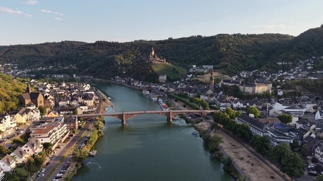 Aerial drone view of Cochem on the Moselle River, Germany, with the historic Reichsburg Cochem castle overlooking the old town, bridge and riverfront. Scenic summer landscape in the Moselle Valley.