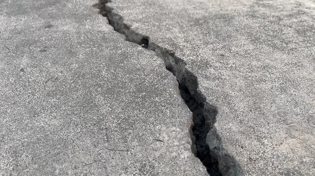 Close Up of Massive Longitudinal Fissure on Broken Pavement