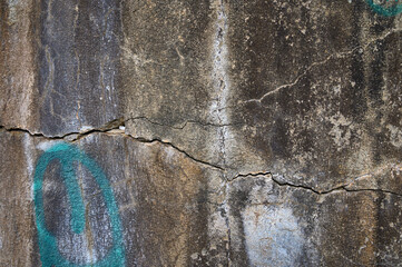 Cracked stone wall adorned with graffiti in a forgotten urban setting under soft © Михаил Шорохов