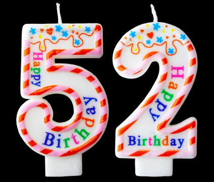 Number fifty two shaped birthday candle with colorful sprinkles and Happy Birthday text isolated on a black background