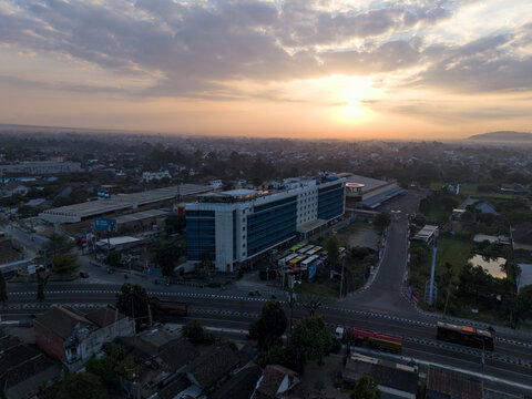Aerial view of INNSiDE by Melia Yogyakarta hotel surrounded by urban landscape and roads during a golden sunset in Kecamatan Depok, Daerah Istimewa Yogya, Indonesia.