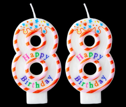 Number eighty eight shaped birthday candle with colorful sprinkles and Happy Birthday text isolated on a black background