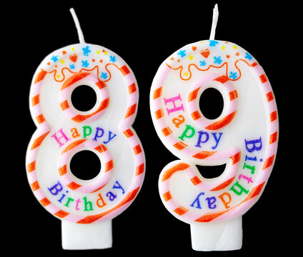 Number eighty nine shaped birthday candle with colorful sprinkles and Happy Birthday text isolated on a black background