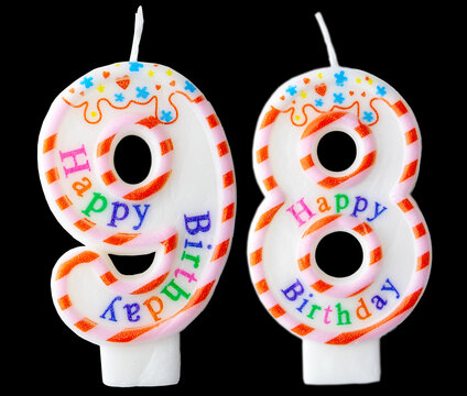 Number ninety-eight shaped birthday candle with colorful sprinkles and Happy Birthday text isolated on a black background