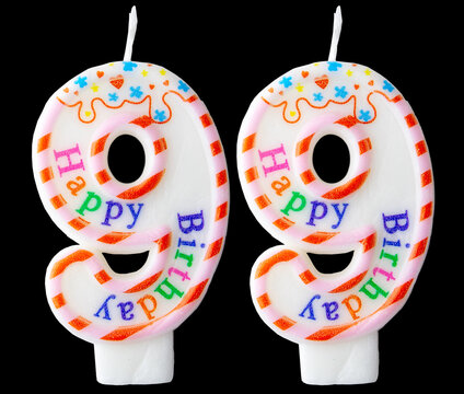 Number ninety-nine shaped birthday candle with colorful sprinkles and Happy Birthday text isolated on a black background