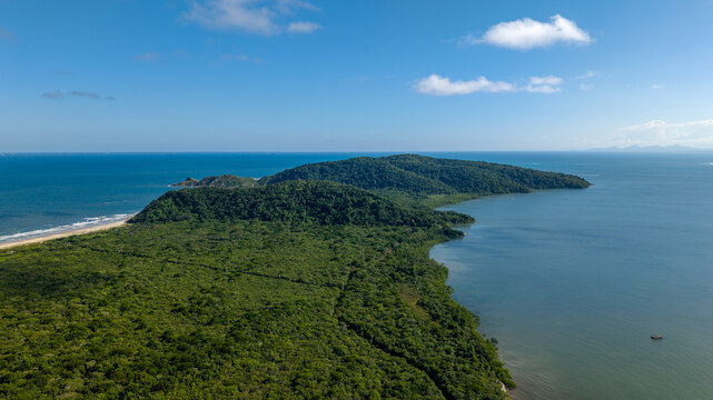 Aerial view of Ilha do Mel featuring lush green forest, sandy coastline, and blue ocean under a clear sky in Paranagua, State of Parana, Brazil.