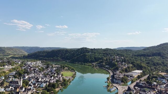 Aerial drone view of Bullay on the Moselle River in Rhineland-Palatinate, Germany, featuring the riverside village, church, river bend and surrounding forested hills in the scenic Moselle Valley.