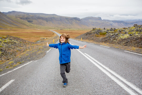 Child, playing on a road near non active vulcano in Snaefellsjokull National Park, Iceland autumntime