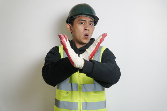 Young Man in Hard Hat and Safety Vest Making a Stop Gesture with Surprised Expression