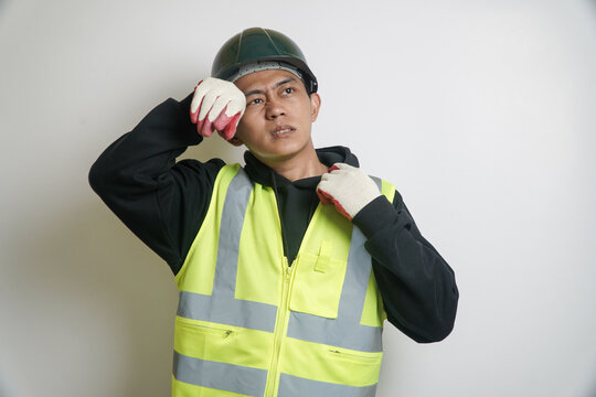 Tired Asian Worker in Safety Vest and Hard Hat Wiping Sweat from His Forehead