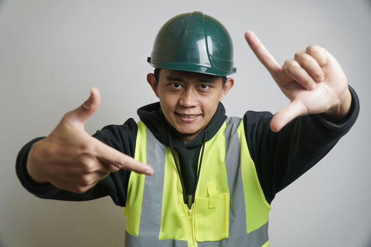 Confident Construction Worker in Hard Hat and Vest Making Frame Gesture