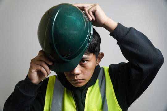 Serious Asian Construction Worker Wearing Reflective Vest and Hard Hat