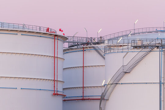 Large oil storage tanks at an industrial refinery facility. Petroleum and fuel storage reservoir tanks in a chemical production plant.