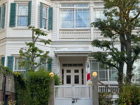 Historic white western-style building entrance with trees in Kobe, Japan