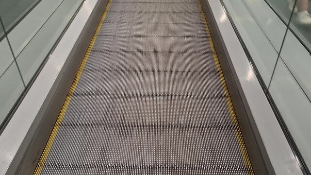 Empty escalator inside a modern commercial building, urban transport, vertical movement, infrastructure, architecture, and retail access.