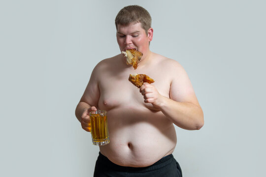 Stomach shows excess abdominal fat. Obese man checks stomach after eating. Large stomach reflects calorie surplus. Stomach problem indicates unhealthy lifestyle.
