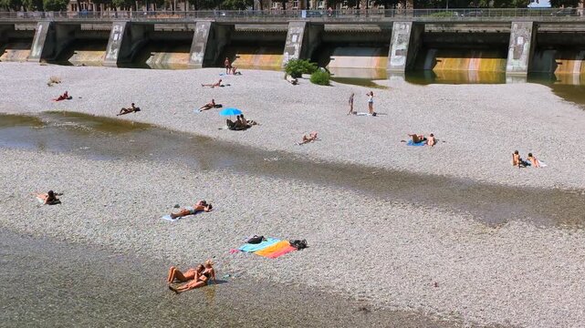 Menschen erfrischen sich am Ufer der k&uuml;hlen Isar an einem hei&szlig;en Sommertag, M&uuml;nchen, Oberbayern, Bayern, Deutschland