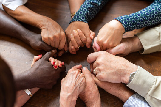 Diverse group of men and women joining hands in a circle of unity